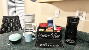 En kaffebar med kaffemaskine, kopper og kaffekapsler.