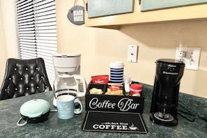 A coffee bar setup with a coffee maker, mugs, and coffee pods. - Beach Retreat, Dog-Friendly, Fenced Yard, Fireplace, Near Ferry (Dauphin Island)