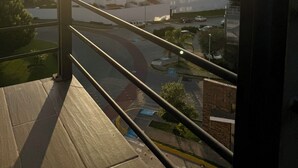 En balkon med udsigt over bybilledet i solnedgangen.