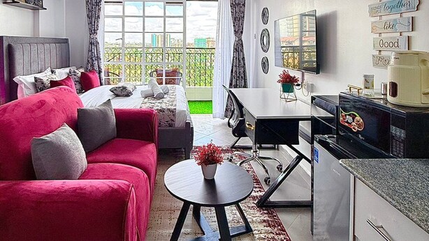 En moderne stue med sofa, sofabord og et spiseområde med bord og stole.