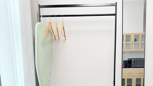 Baño con tocador de madera, barra de cortina de ducha colgante, espejo y organizador de ducha.