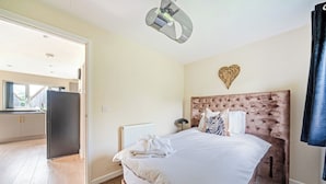 Una camera da letto con un letto, un termosifone, un lampadario a soffitto e una decorazione a forma di cuore sulla parete.