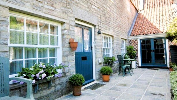 A stone building with a blue door, windows, and a tiled roof. - Stylish Retreat in the Heart of Somerton with Wood Fire (Somerton)