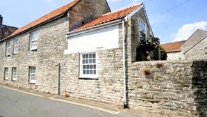 A stone building with a red-tiled roof, a white upper section, and a brick lower section. - Stylish Retreat in the Heart of Somerton with Wood Fire (Somerton)