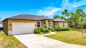 A two-story residential house with a garage, a well-maintained lawn, and a clear blue sky. - 15261 Brainbridge Circle, Port Charlotte, FL 33981 (Charlotte County)