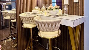 Une cuisine moderne avec un mur d’accent en bois, un coin bar avec des tabourets et un lustre.