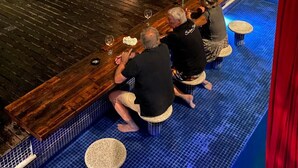 A bar area with wooden furniture, a fire pit, and a pool with blue tiles. - House with sea and cliff views, 100m from the beach in Trancoso. (Trancoso)