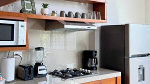 A modern kitchen with a microwave, stove, and refrigerator. - Star Department We Bill (La Paz)