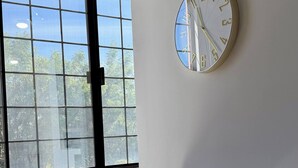 A room with a large window, a wall-mounted clock, a desk, and two chairs. - Star Department We Bill (La Paz)