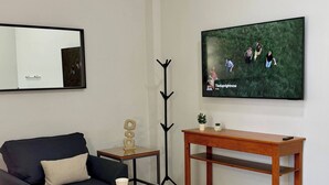 A modern living room with a sofa, coffee table, TV, and a decorative plant. - Star Department We Bill (La Paz)