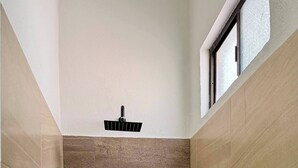 A shower area with a window, tiled walls, and a built-in shelf. - Star Department We Bill (La Paz)