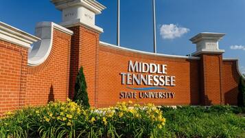 Een gebouw van baksteen met het bord 'Middle Tennessee State University' en een wimpel.