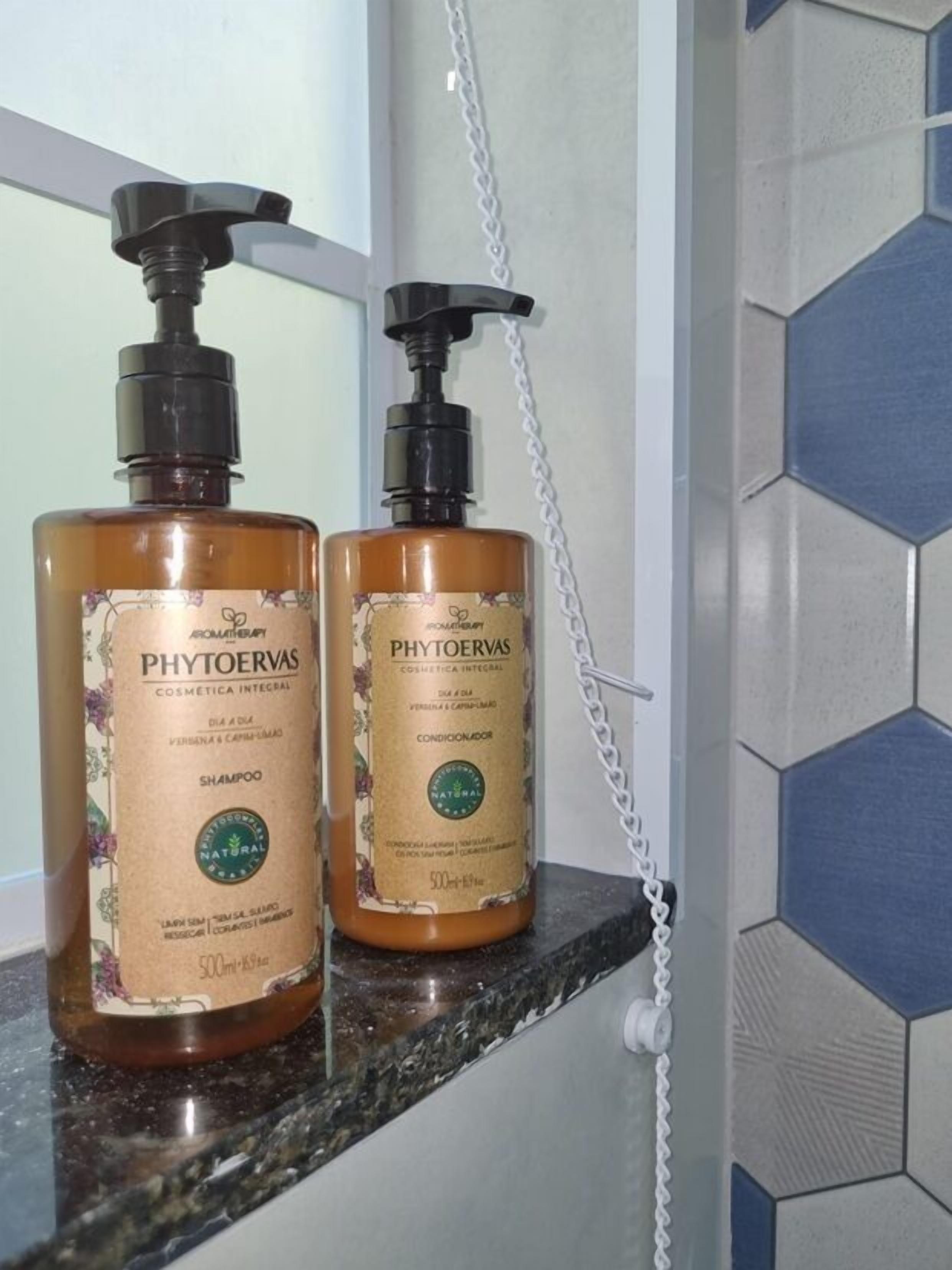 Two bottles of Phytoervas shampoo on a marble countertop.