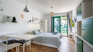 Ein gemütliches Schlafzimmer mit Bett, Nachttisch und Schreibtisch mit Stuhl.