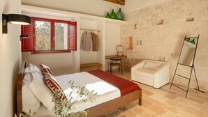 A bedroom with a bed, a chair, a desk, and a painting on the wall. - Trulli D Amore (Monopoli)