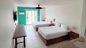 A modern hotel room with two beds, a desk, a small table, a round seating area, and a view of the outdoors.
