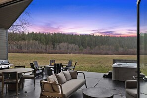 Una terrazza esterna con divano, sedie, barbecue e vasca idromassaggio.
