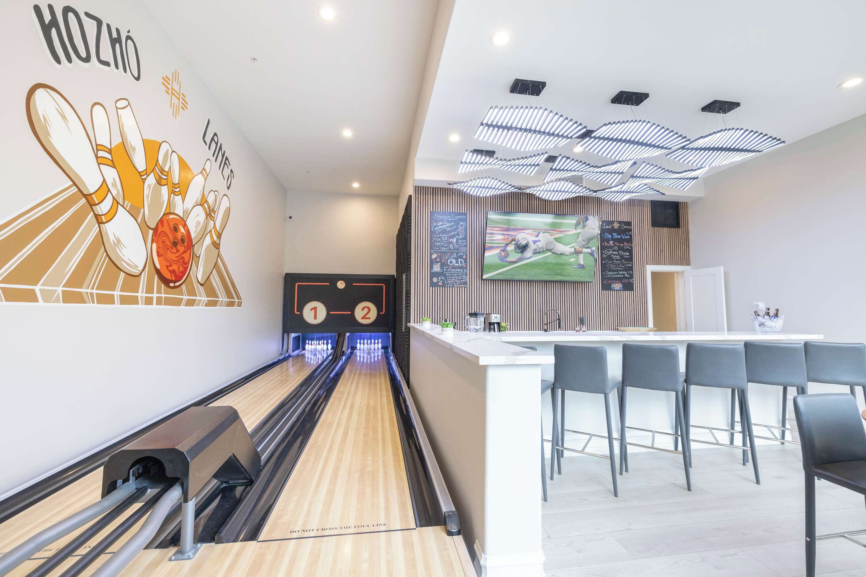 A bowling alley with a modern design, including a bowling lane, pins, and a scoreboard.