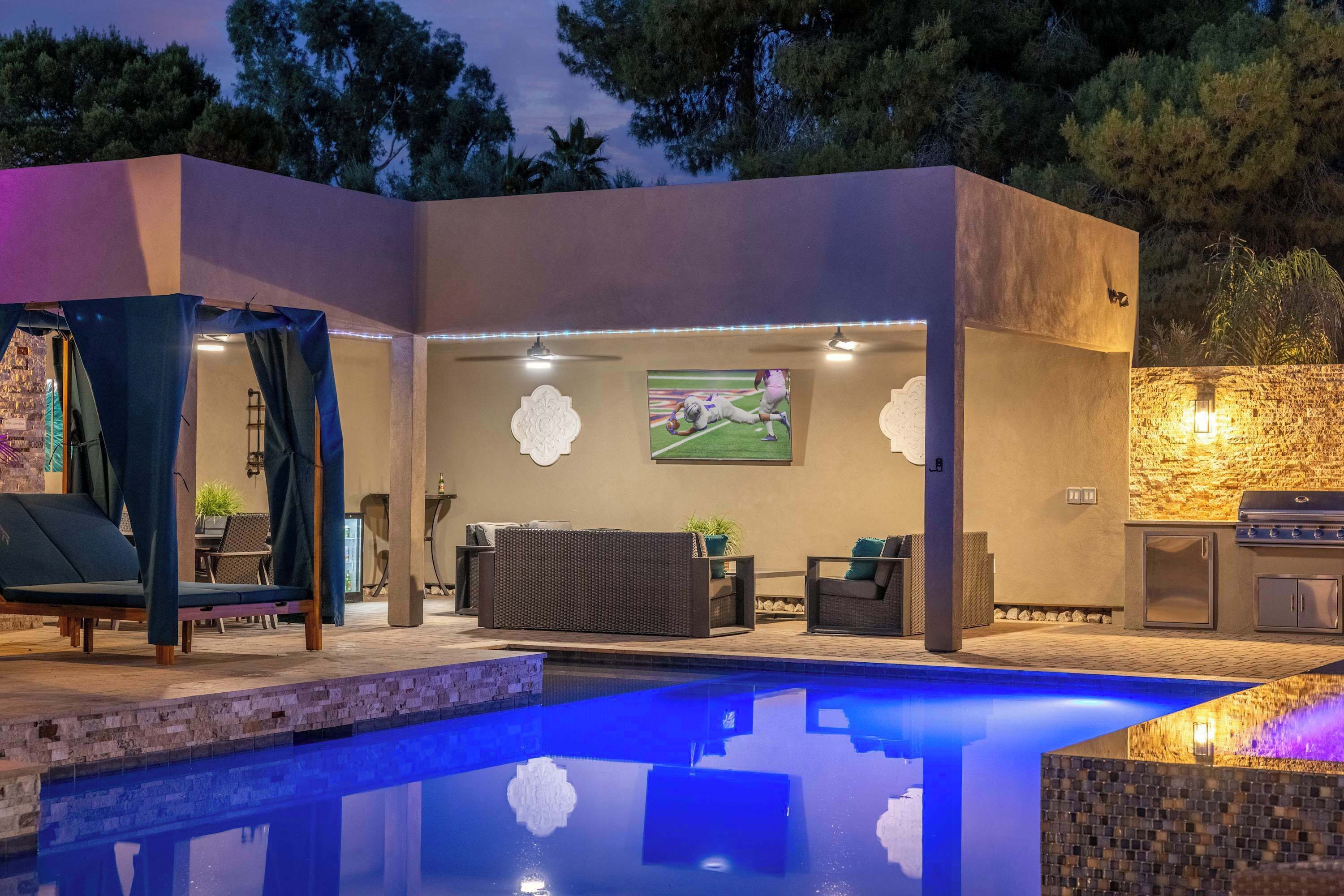 Area piscina esterna moderna con una sedia a sdraio, un angolo relax e una stazione barbecue.