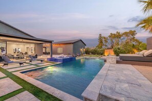 A modern house with a swimming pool, outdoor seating, and a well-maintained lawn. - HÓZHÓ | Pool, Hot Tub, Putting Green & Game Room (Scottsdale)