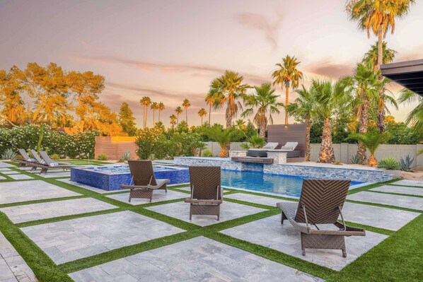 A pool area with lounge chairs, a hot tub, and palm trees. - HÓZHÓ | Pool, Hot Tub, Putting Green & Game Room (Scottsdale)