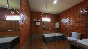 A bathroom with a bathtub, toilet, and a mirror.