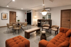 A modern living room with a round dining table, cushioned chairs, a glass coffee table, and a sofa. - Apartment near the Las Ventas Bullring (Madrid)