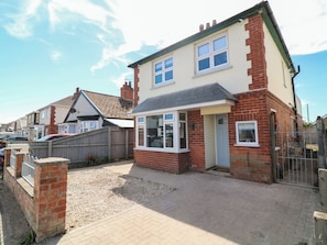 A two-story house with a front garden, a garage, and a visible number '54' on the door. - 54 George Street (Mablethorpe)