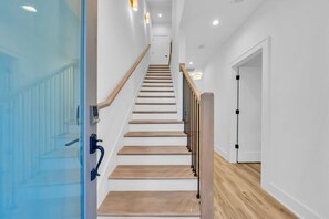 A staircase with wooden steps and a glass door on the left. - Nashville Hideaway - Rooftop - Fire Pit Nights (Nashville)
