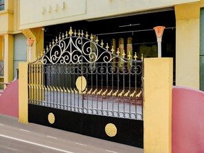 A gated entrance with ornate metalwork and circular decorative elements. - Deluxe Guna Residency (Tirupporur)