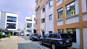 Eine Straße mit modernen Gebäuden, geparkten Autos und blauem Himmel.
