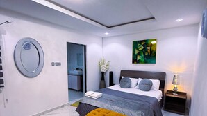 Ein modernes Schlafzimmer mit einem Bett, einem runden Spiegel, einem Gemälde und einem Nachttisch.