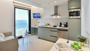 Ett modernt kök med utsikt över havet, en matplats med ett bord och en soffa.