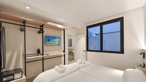 A modern hotel room with a bed, a desk, a wardrobe, and a large window. - 1 bedroom interior apartment (Las Palmas de Gran Canaria)