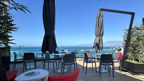 An outdoor seating area with tables and chairs, a swing, and a view of the ocean. - Top Floor Penthouse Studio (Las Palmas de Gran Canaria)