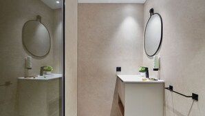 A modern bathroom with a glass shower enclosure, a white vanity with a mirror, and a small potted plant. - Top Floor Penthouse Studio (Las Palmas de Gran Canaria)