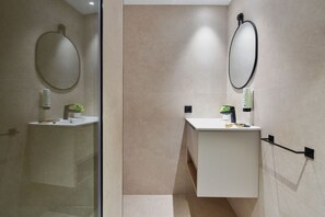 A modern bathroom with a glass shower enclosure, a white vanity with a mirror, and a small potted plant. - Top Floor Penthouse Studio (Las Palmas de Gran Canaria)