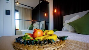 Een bed met een rieten fruitmand, een kussen en een nachtkastje met een lamp.