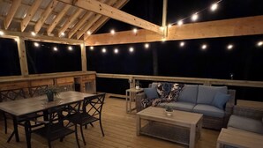 An outdoor deck with a wooden table and chairs, a sofa, and a coffee table. - 
Charming 2 bed room mountain hideaway in Murphy (Murphy)