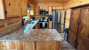 A kitchen with wooden cabinets, granite countertops, stainless steel appliances, and a wooden ceiling. - 
Charming 2 bed room mountain hideaway in Murphy (Murphy)