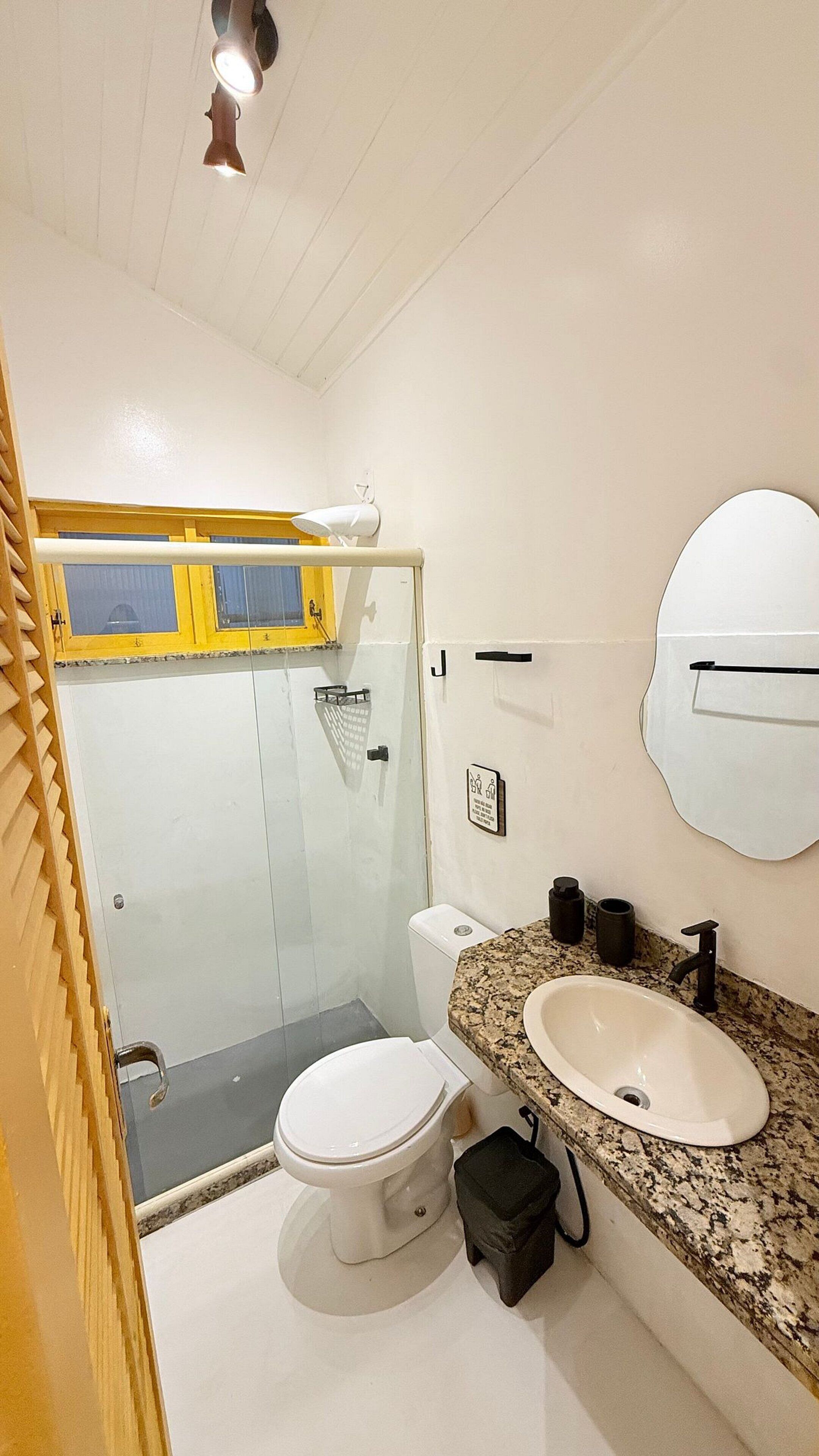 Une salle de bain comprenant des toilettes, un lavabo et un espace douche.
