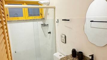 Une salle de bain comprenant des toilettes, un lavabo et un espace douche.
