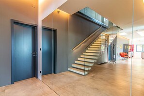 Ein modernes Interieur mit Treppe, Türen und einem Sessel.