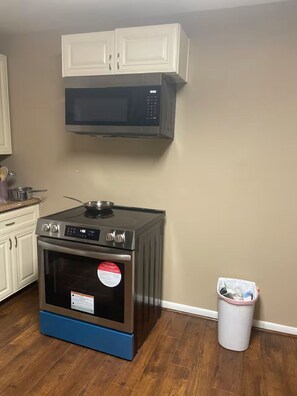 A kitchen with a microwave, oven, and cabinets. - Lofty Grace Home 2 (Richmond)