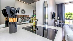 Une cuisine moderne dotée d’un plan de travail noir, d’une cuisinière encastrée et d’une machine à café.