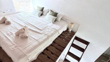 Tabla de planchar con plancha, internet y ropa de cama