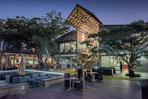 An outdoor area with seating, a staircase, and a building with a unique roof structure. - Simbithi Estate Escape | 4xBed | Air-conditioned (Dolphin Coast)