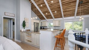 A spacious kitchen with a large island, wooden ceiling beams, and a view of the outdoors. - Ocean Sound - 2nd Row - 4BR Folly Field Beach House - Heated Private Pool (Hilton Head Island)