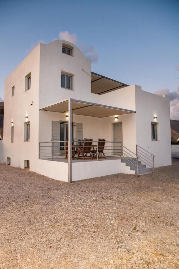 A modern two-story house with a covered patio, a staircase, and a gravel driveway. - DENIS Summer Living (Santorini)