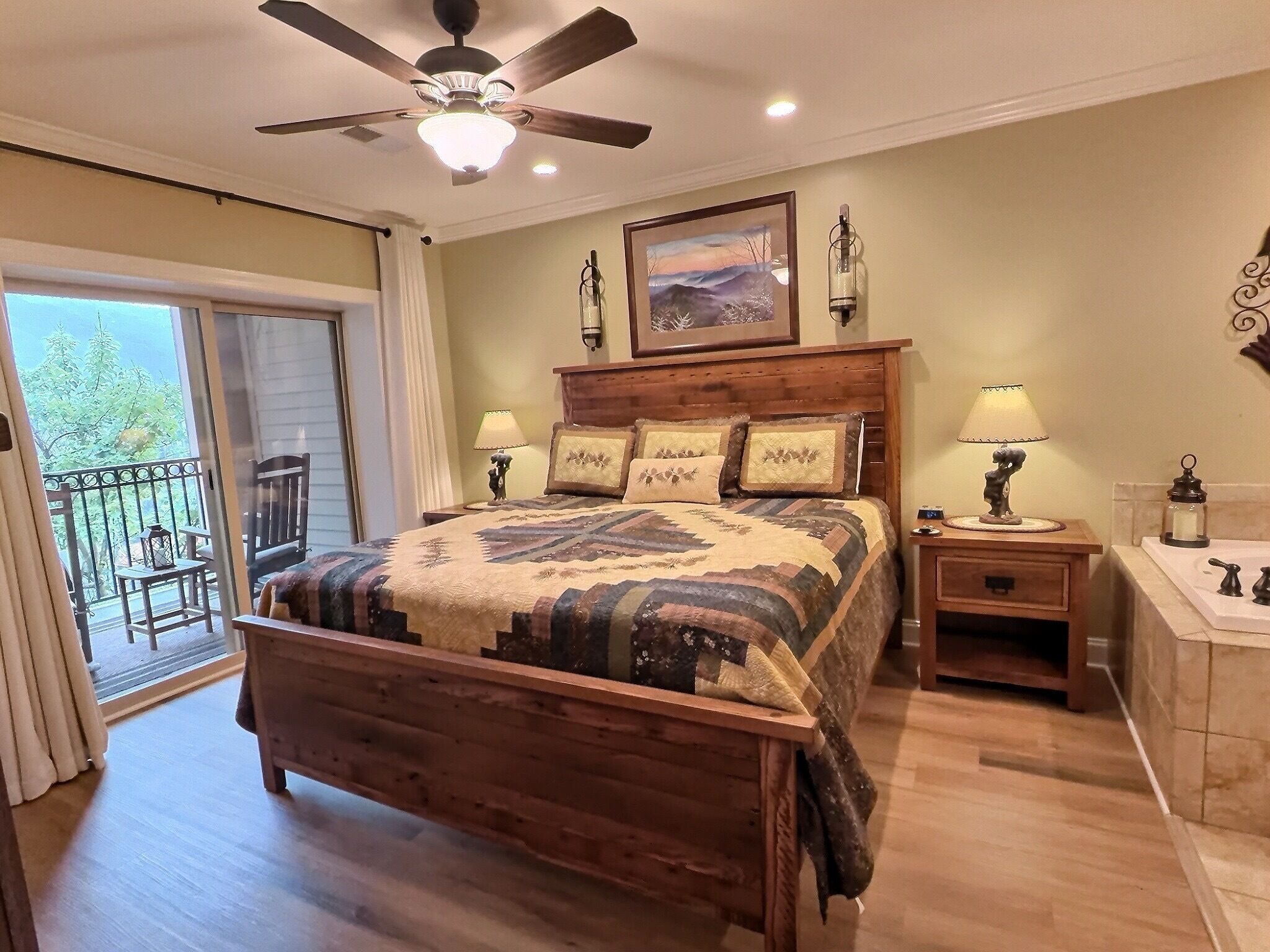 Primary bedroom with mountain-inspired bedding and private balcony access.